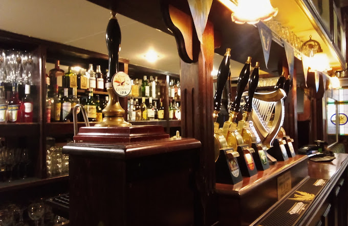 Gruppo di amici che brinda con le birre in un pub